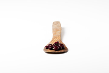 Group of red beans on a wooden spoon on a white background