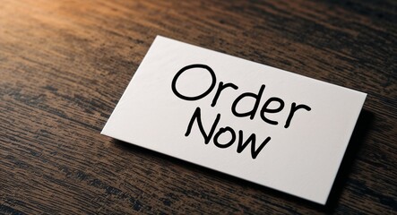 Order now word written on a business card on table