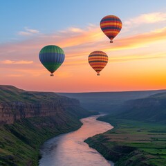 Fototapeta premium Three hot air balloons fly over a scenic river canyon at sunset.