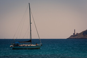 Sailboat at anchor in front of the Punta Palascia Lighthouse.