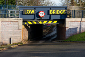 Low bridge warning sign indicating height restriction for vehicles passing underneath