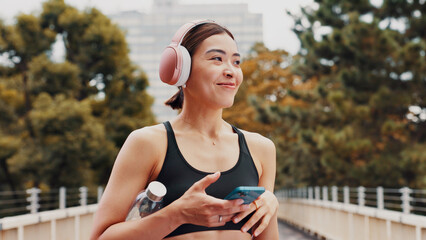 Thinking, woman and headphones with fitness in city, listening to music and sports podcast. Female...