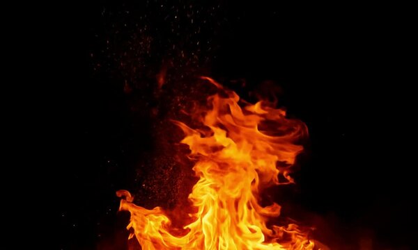 Intense Flames Erupting from Dark Background with Glowing Embers and Sparks