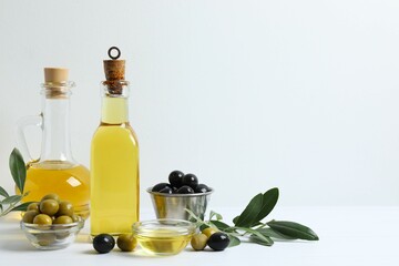 Bottle of fresh olive oil and olives on table