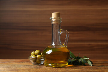 Bottle of fresh olive oil and olives on table