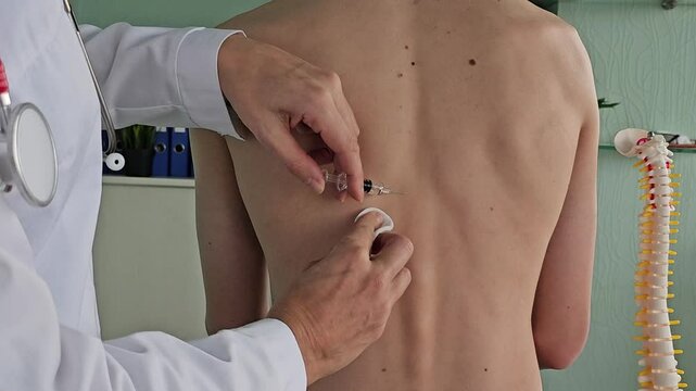 A doctor gives an injection to a patient in a clinical setting, paying special attention to the health of the spine 
