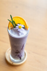 Glass of blueberry smoothie with orange and rosemary