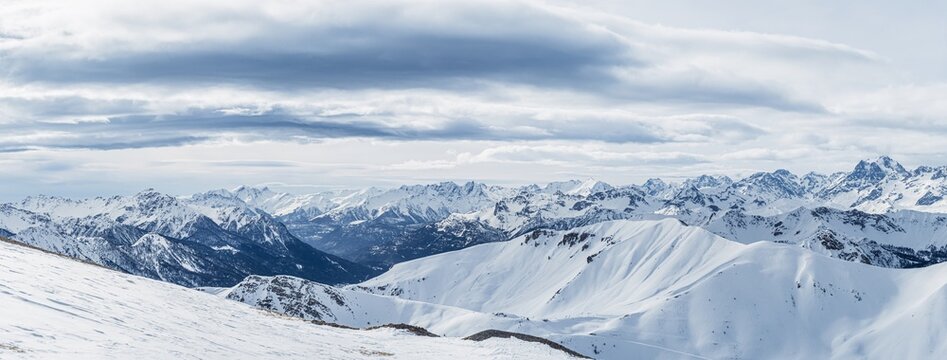 Snowy Alpine mountain panorama with cloudy sky