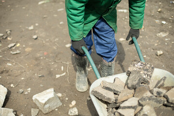 Transportation of broken stone. Worker dismantles block of stones.