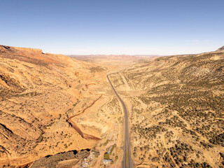 
Road passing in amazing landscape of south western USA in Utah, in winter, with high mountains, mesas, cliffs, canyons and a small river. Blue sky and sunlight