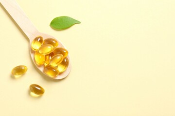 Wooden spoon on a color background. Fish oil tablets. Biologically active additives. Omega 3, 6,...
