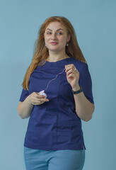 A pretty young dentist girl holds an unfolded dental floss in her hands. The concept of healthy teeth