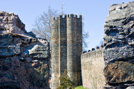 Perspectiva de uma torre inserida nas muralhas de um castelo. Vista por entre os buracos deixados pela muralha. Em Bragan&ccedil;a, Portugal.