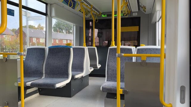 Empty seats in Greater Manchester tramway or tram carriage riding in Salford city residential district, Weaste area.