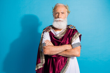 Photo of attractive old man confident crossed hands dressed greek god emperor actor costume isolated on blue color background