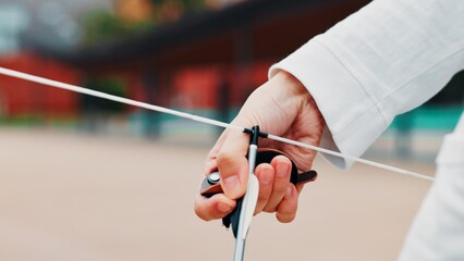 Archery, person and hands with arrow, bow or string for aim, skill or talent in preparation for...