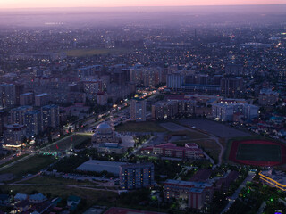City landscape. Evening view from a drone of the city at sunset. Trees, roads, streets, cars and...