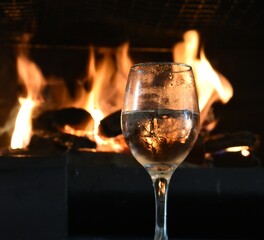 Wine of glass in front of fireplace 