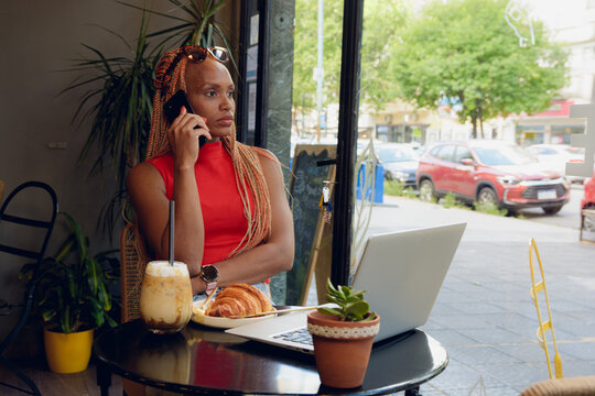 Young woman in cafe talking on phone seriously