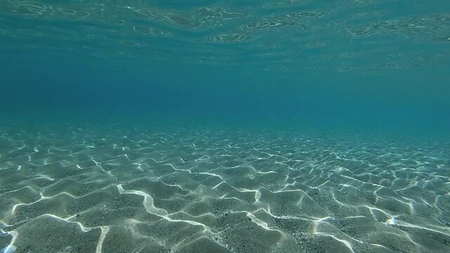 underwater footage short turquoise clean waters sun pattern on sand texture
