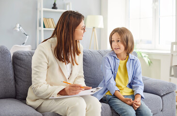 Portrait of a friendly young female psychologist woman doctor talking with her child girl patient...