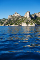 View from the Mediterranean Sea to the rocky coast of the Calanque National Park on a sunny summer day.