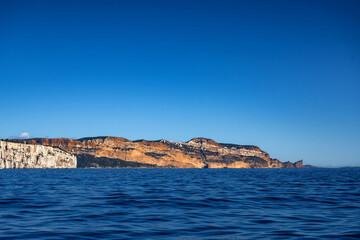 View from the Mediterranean Sea to the rocky coast of the Calanque National Park on a sunny summer day.