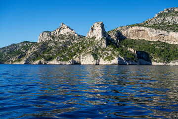 View from the Mediterranean Sea to the rocky coast of the Calanque National Park on a sunny summer day.