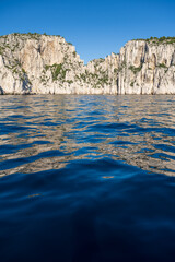 View from the Mediterranean Sea to the rocky coast of the Calanque National Park on a sunny summer day.