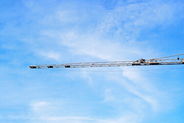 Brazo de grúa de construcción sobre cielo con nubes