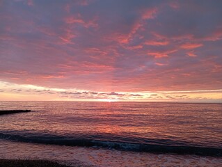 sunset on the beach. Red sunset on the sea. The sun is setting over the sea horizon