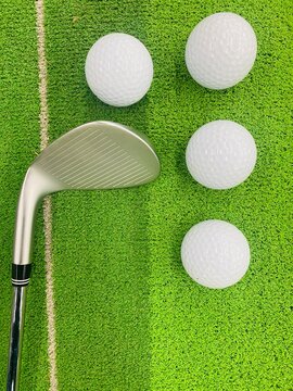 Golf balls with golf stick on the green grass