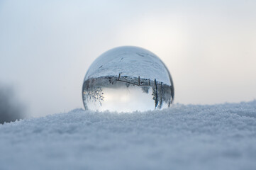 Snow-covered landscape is reflected in a sphere
