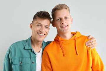Fototapeta premium Portrait of two happy brothers on light background