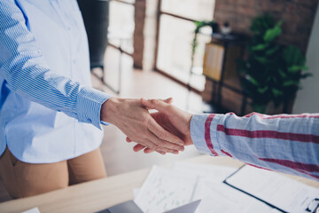 Two professionals shake hands in a modern office, creating a harmonious business connection that symbolizes agreement and partnership.