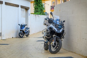 Two motorcycles parked in an alley