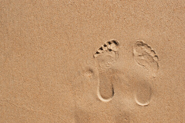 Top view of footprints on sand with space for text