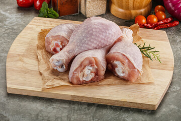 Raw uncooked chicken drumsticks over board