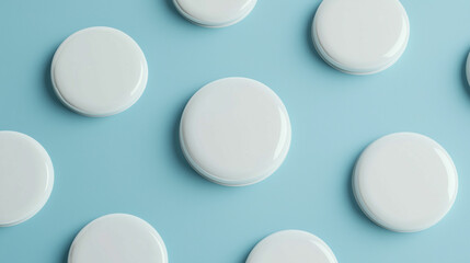 Various white circular objects arranged on a light blue background in a minimalist style