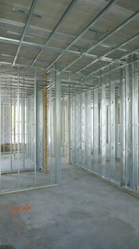 Interior of building under construction focusing on house framing. Metal studs and tracks that form skeleton of walls and ceiling. Essential components in modern construction