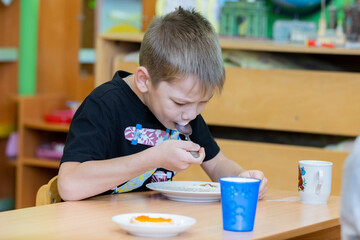 Russia. Saint-Petersburg. A child in kindergarten is having breakfast.