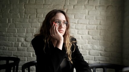 Woman Writing in a Notebook with Laptop Nearby