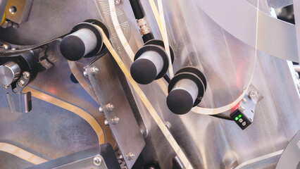 Fragment of the conveyor of sticking labeling machine. Abstract industrial background.