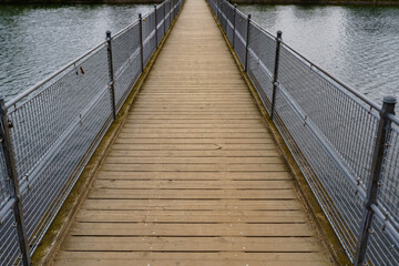 Obraz premium A small pedestrian bridge over a calm water surface