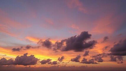 Fototapeta premium Colorful and vibrant sky during sunset, featuring a blend of deep purples, pinks, oranges, and blues, clouds, peaceful, vibrant