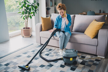 Fototapeta premium Full body photo of ginger young girl stressed repair vacuum cleaner talk phone wear blue clothes enjoy modern cozy interior flat indoors