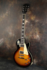 Obraz premium Old electric guitar against the background of a red concrete wall.