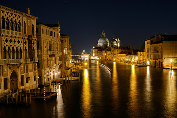 Obraz premium Venice, Italy: Night view of Venice Grand Canal with boats and Santa Maria della Salute church on sunset from Ponte dell'Accademia bridge. Venice, Italy
