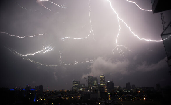 Thunder and lightening over cityscape at night, Canary Wharf, London, England, UK
