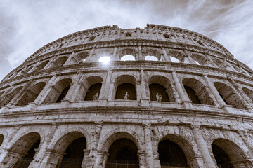 Obraz premium The great Roman Colosseum also known as the Flavian Amphitheater on a sunny day with deep blue sky, beautiful clouds and no people visible 